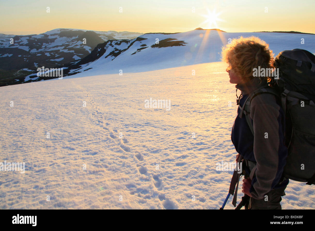 Backpacker looking back at sunrise while crossing Drangajökull ice cap, Hornstrandir Peninsula, Iceland Stock Photo