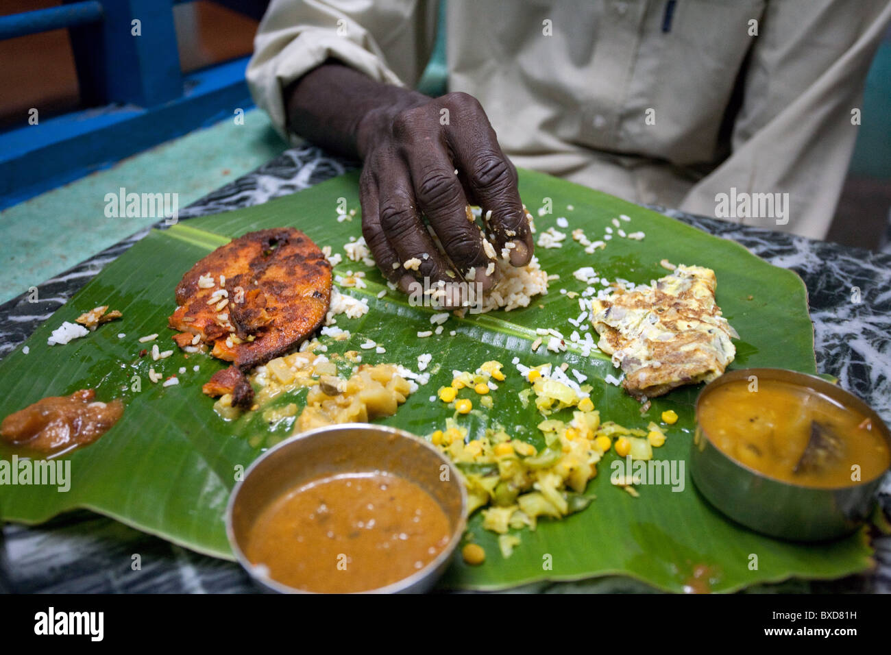 A man eats South Indian meal with his hand in Mamallapuram, India Stock