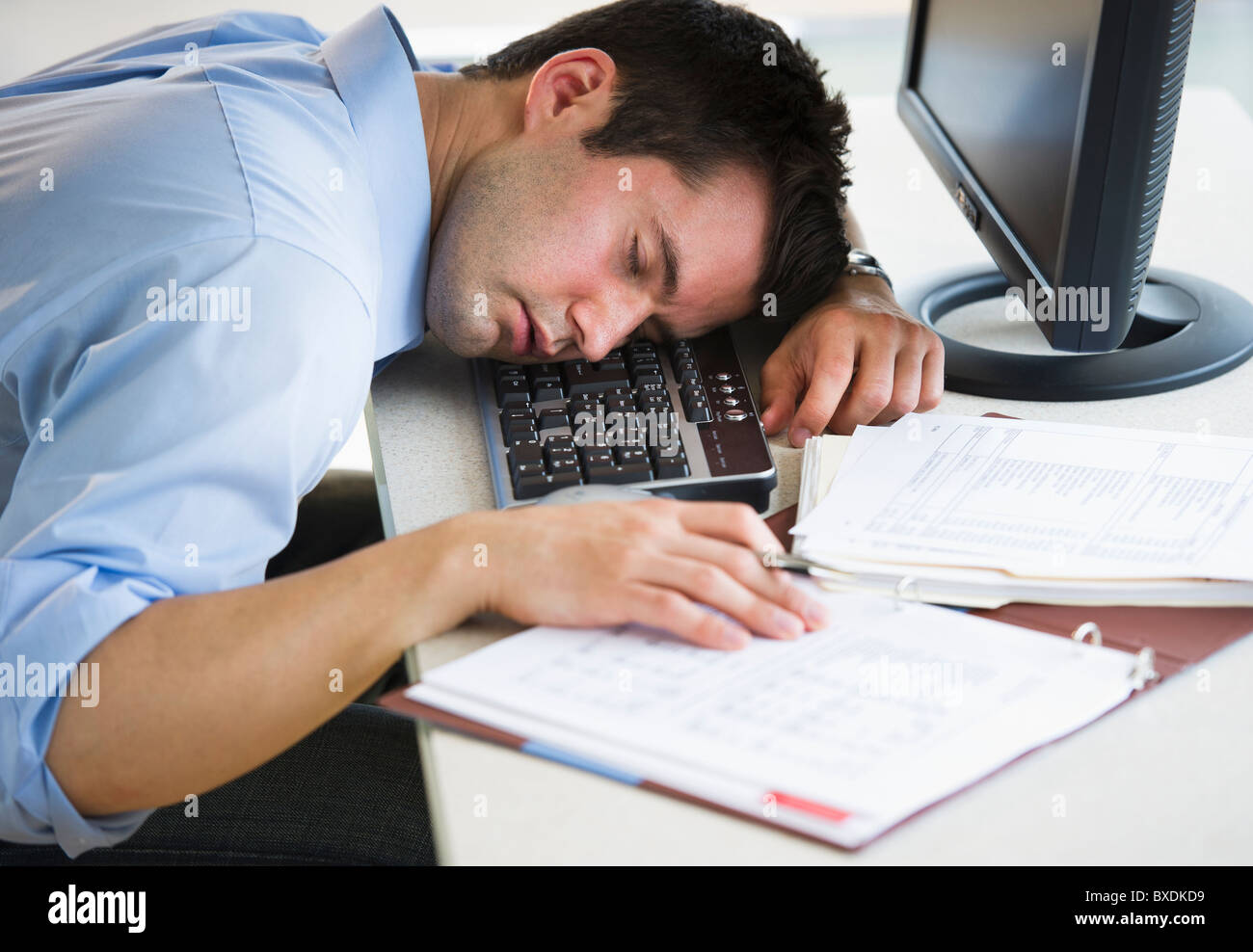 Businessman asleep at his desk Stock Photo