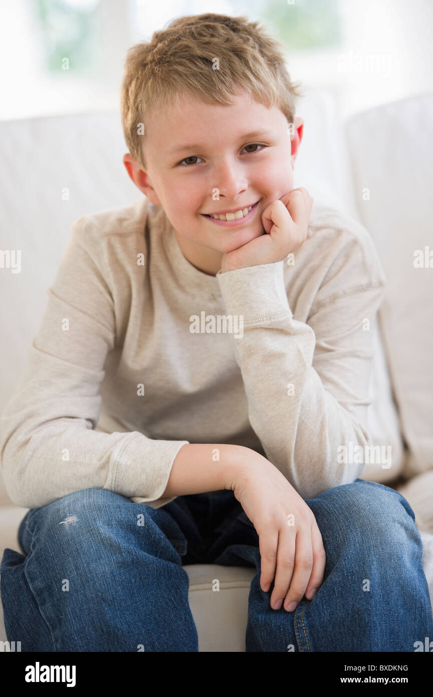 Young boy sitting on couch Stock Photo