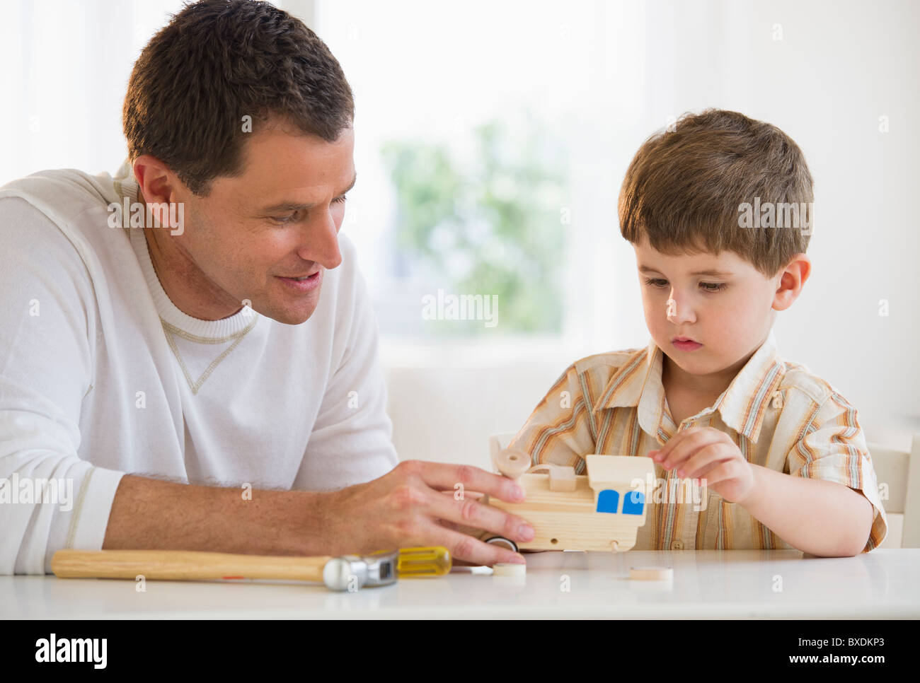 Father and son building a wooden train Stock Photo