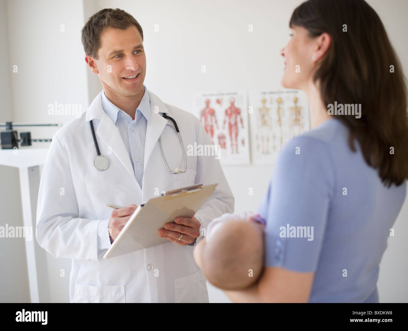 Doctor talking to woman in examination room Stock Photo