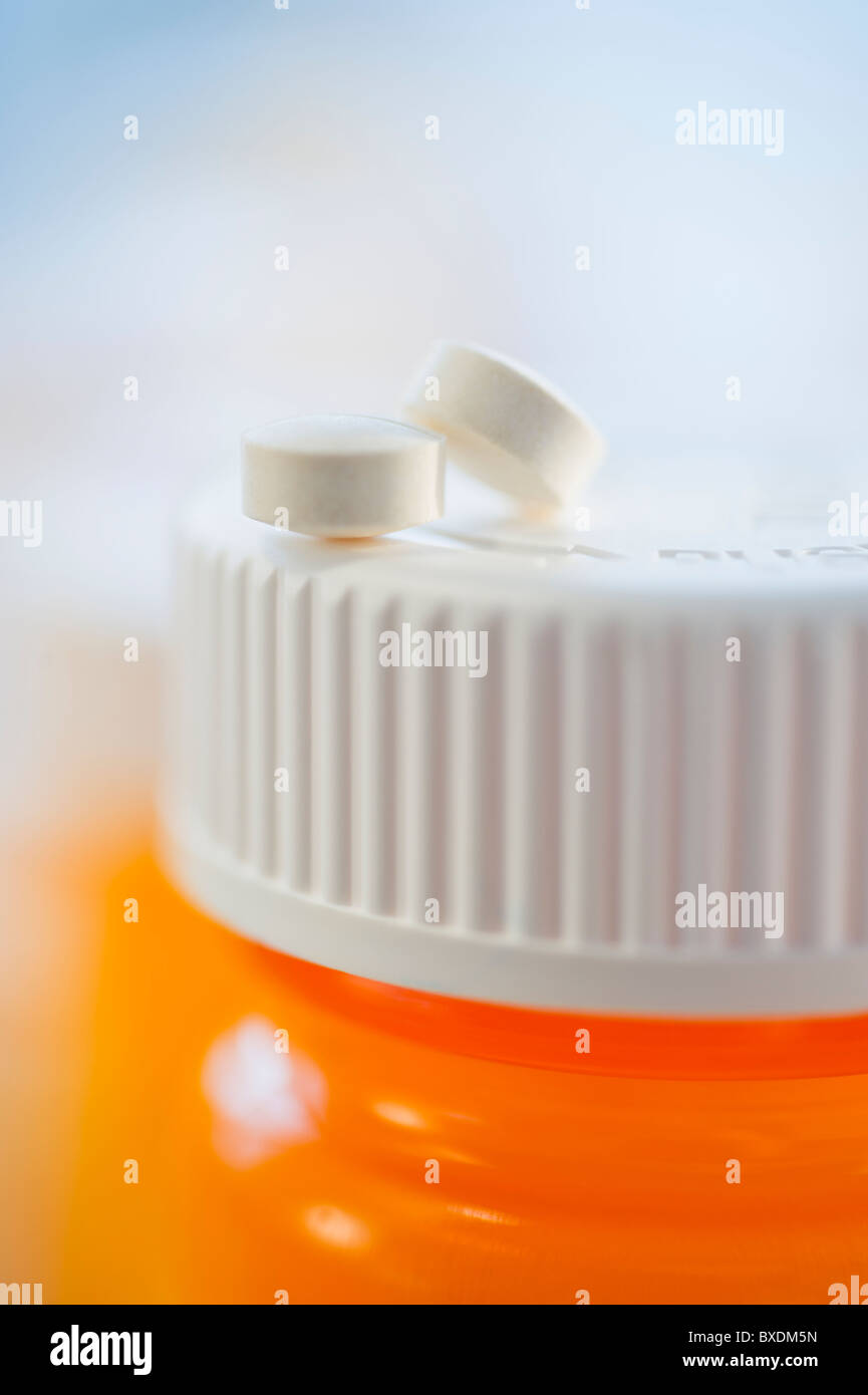 Pills on top of bottle of prescription medication Stock Photo