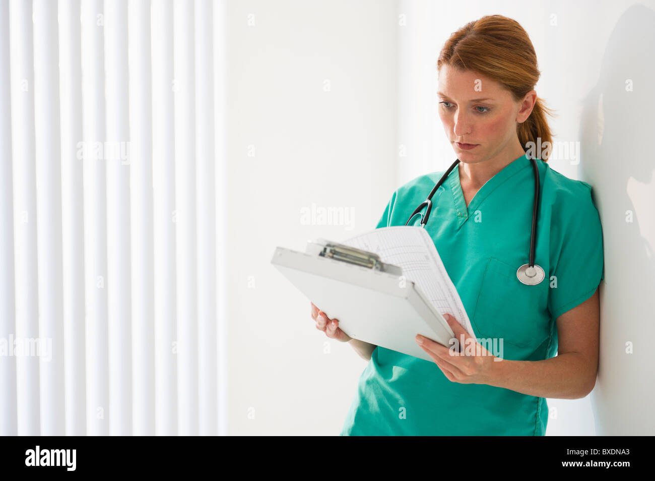Healthcare worker looking at medical chart Stock Photo