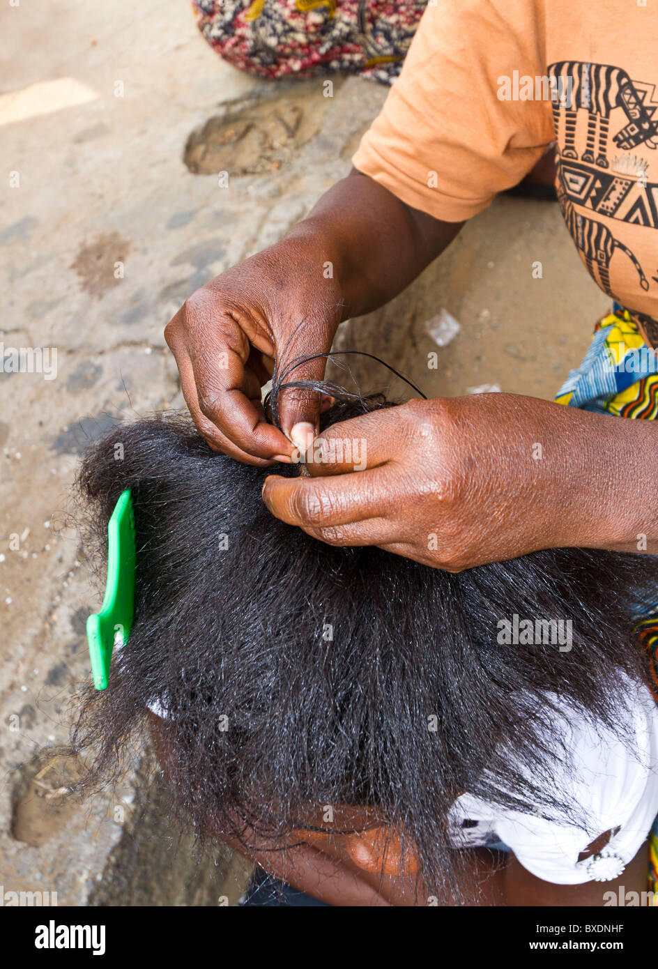 Woman braids hair of friend at craft village in Zambia Stock Photo Alamy