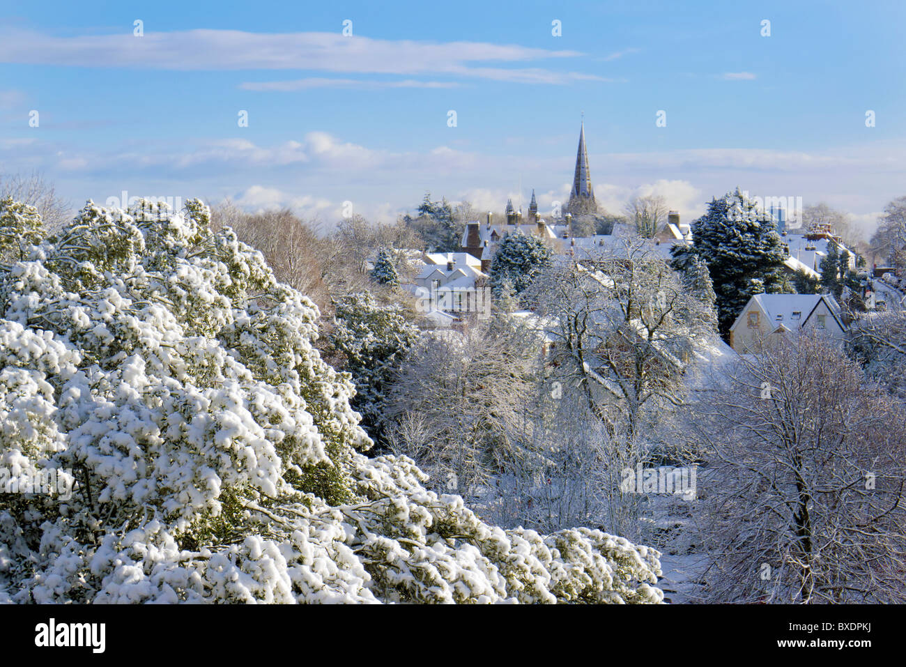 Winter scene with church spire,village and tress under new snow Stock Photo