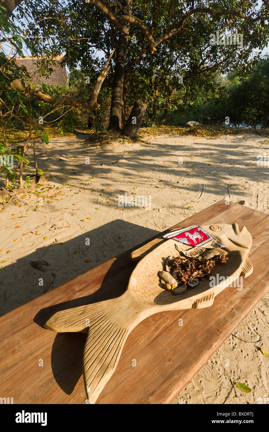 Table with carved dish at Sindabezi, luxury honeymoon resort in Livingstone, Zambia, Africa. Stock Photo