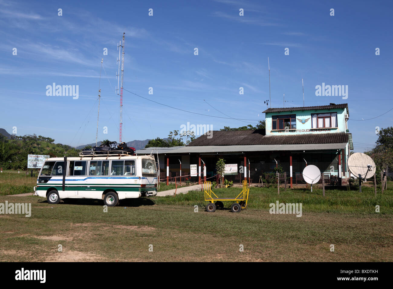 Airport bus on grass runway outside airport terminal building, Rurrenabaque , Beni department,  Bolivia Stock Photo