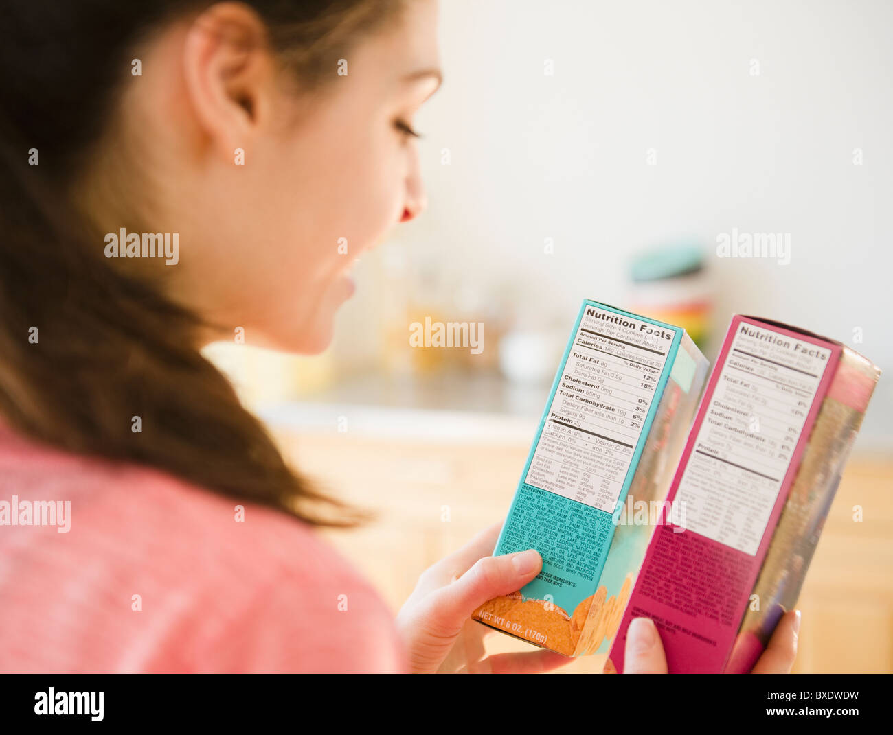 Woman reading nutrition facts on food packaging Stock Photo