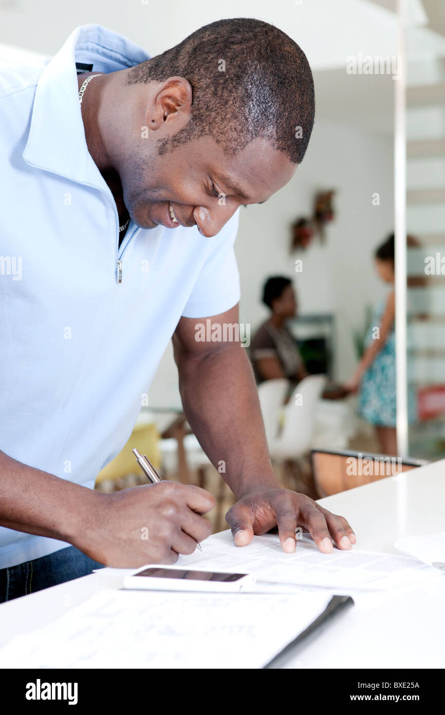 Smiling Black man writing Stock Photo - Alamy