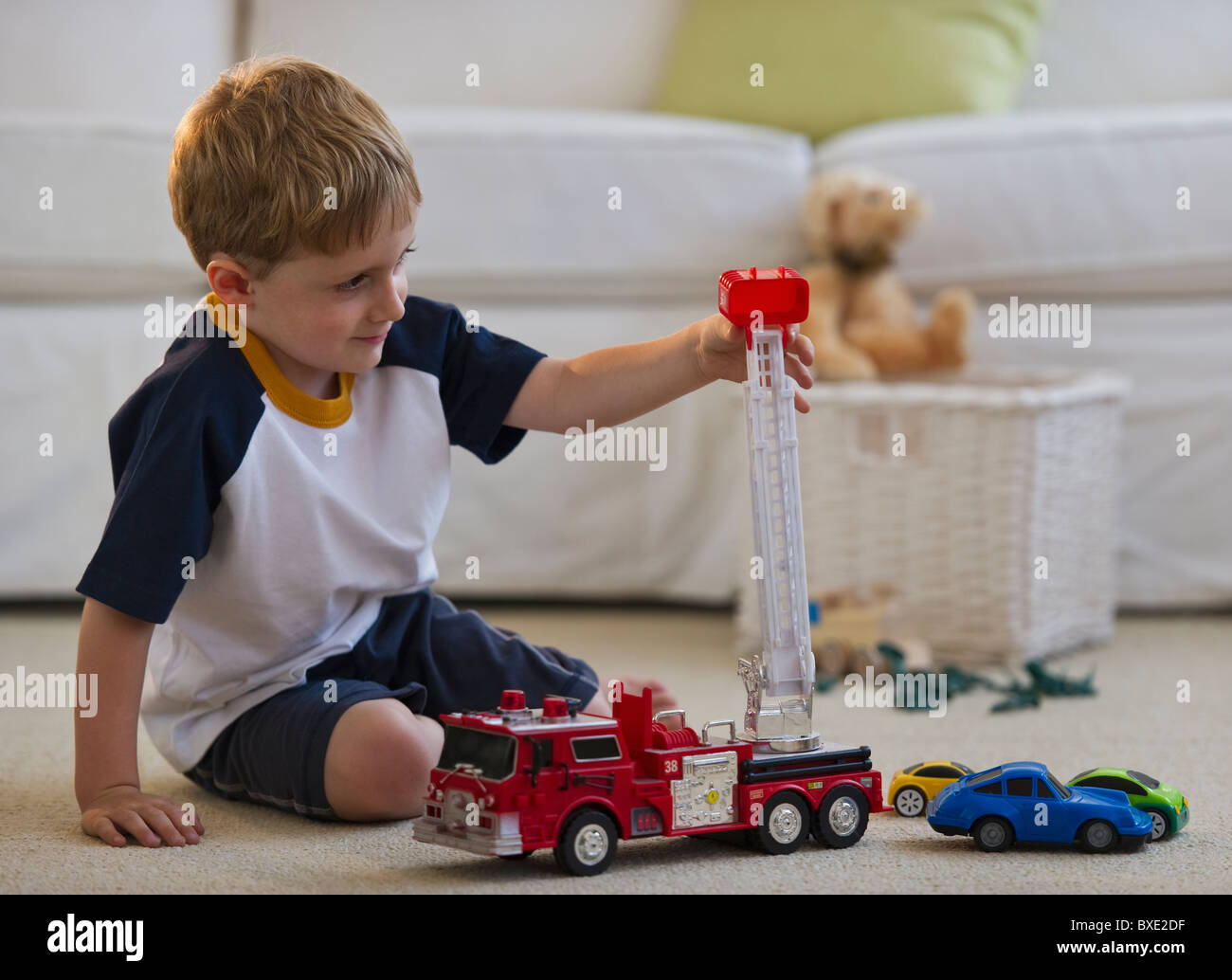 Young boy playing with toy fire truck Stock Photo
