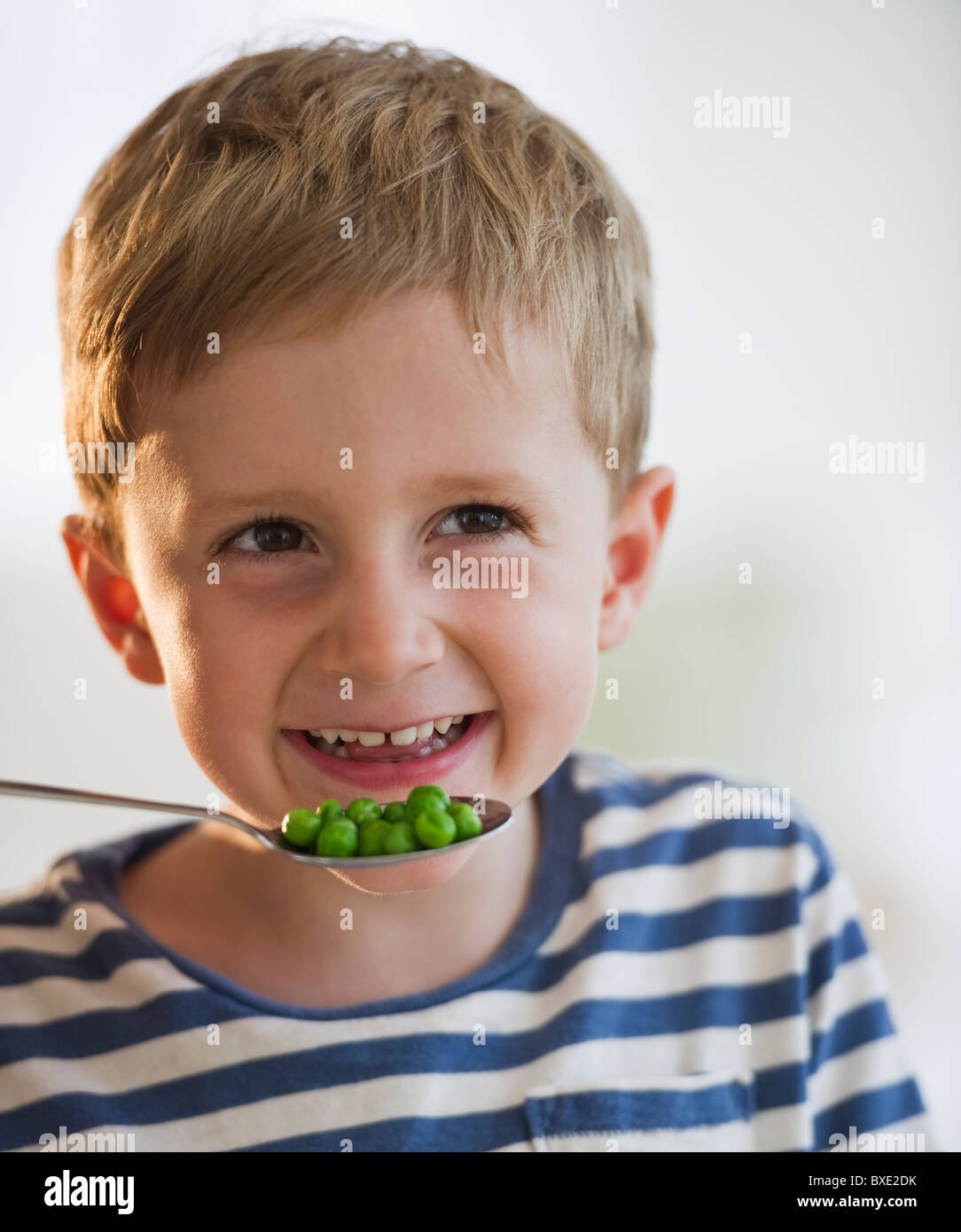 Young boy eating peas Stock Photo Alamy