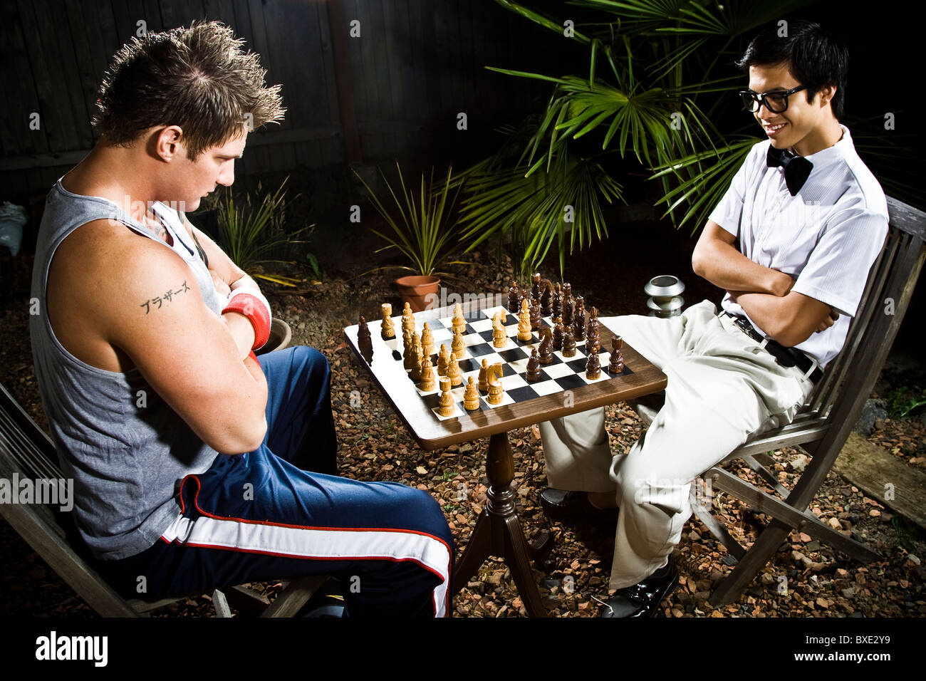 Geek and body builder playing chess Stock Photo