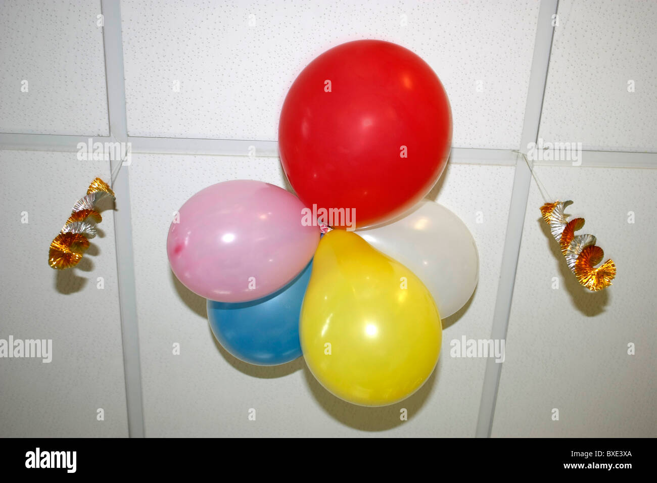 red yellow blue pink white balloons hanging on top of roof decorated for Christmas celebration Stock Photo
