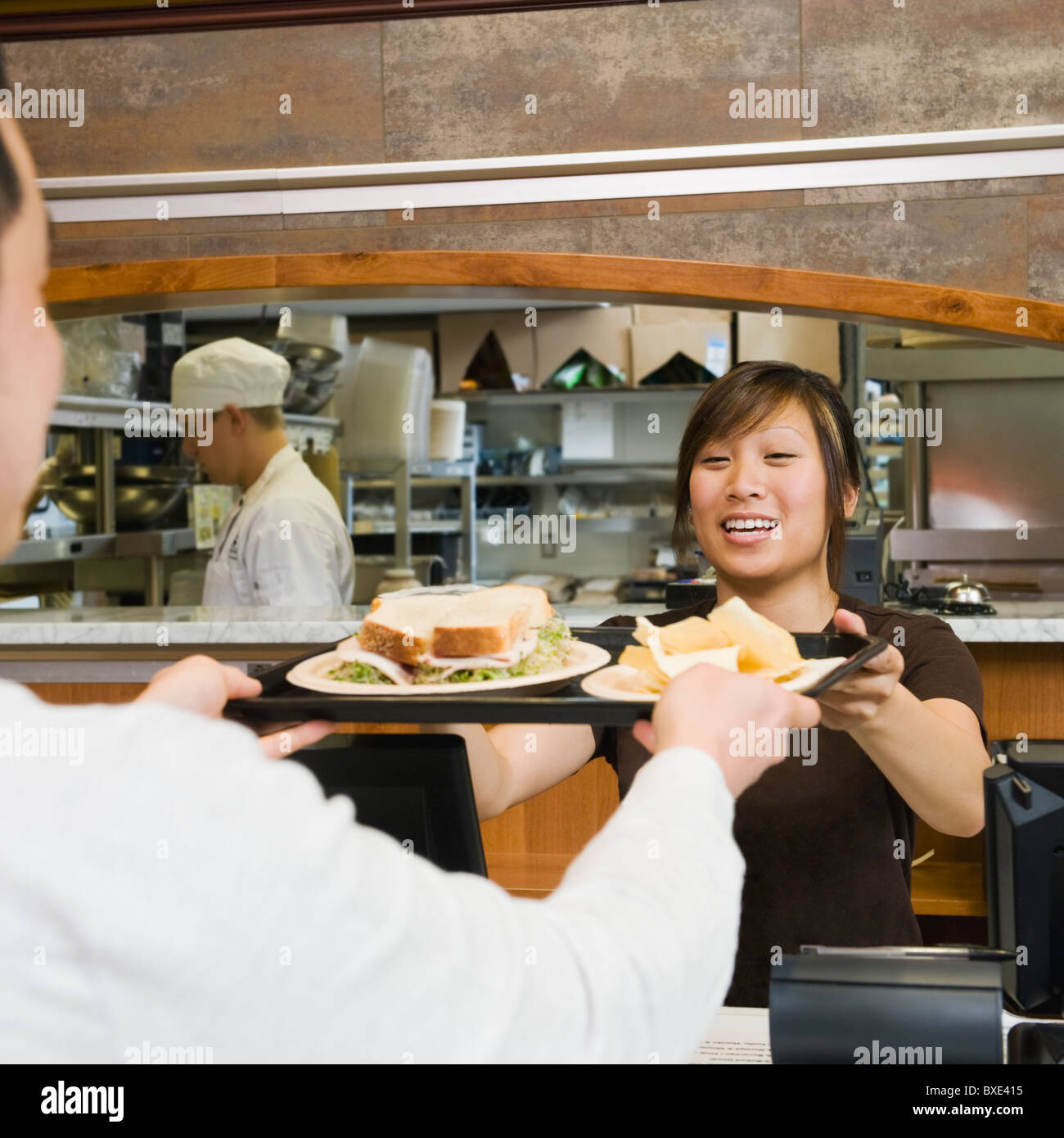 Customer receiving tray of food in bakery Stock Photo