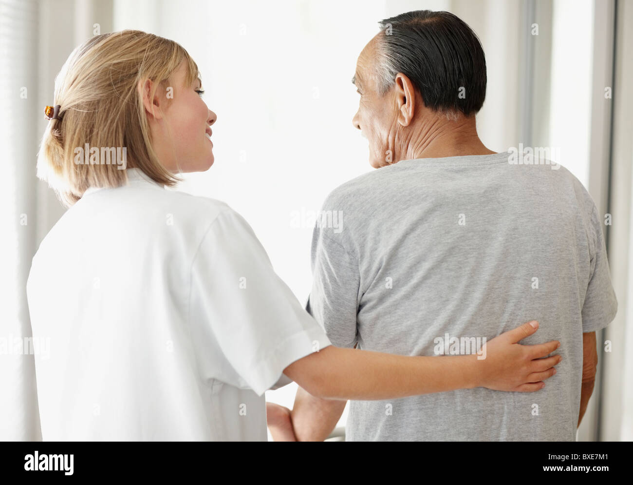 Nurse assisting patient with a walker Stock Photo Alamy