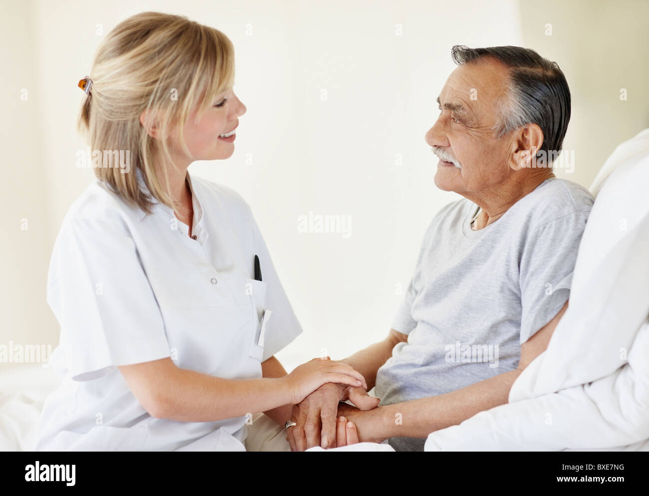 Nurse sitting with patient Stock Photo Alamy