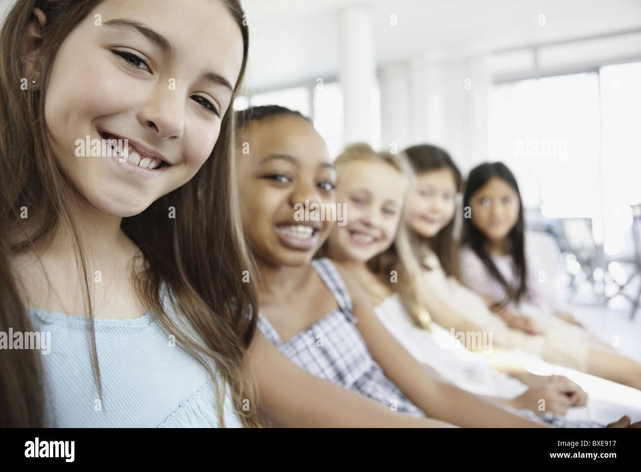 Group of young girls sitting in a row Stock Photo Alamy