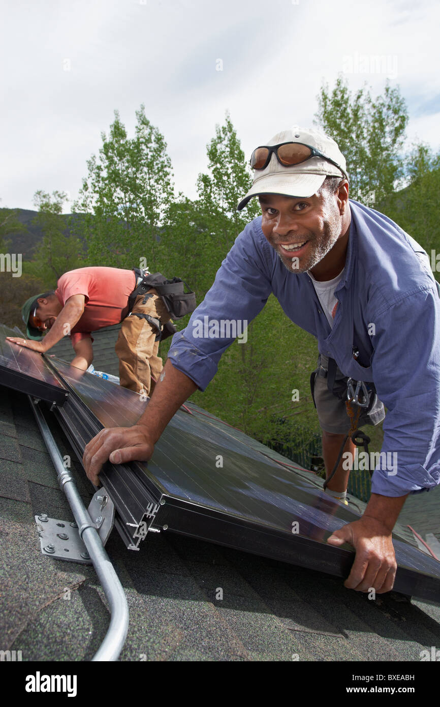 Construction workers installing solar panels on roof Stock Photo Alamy