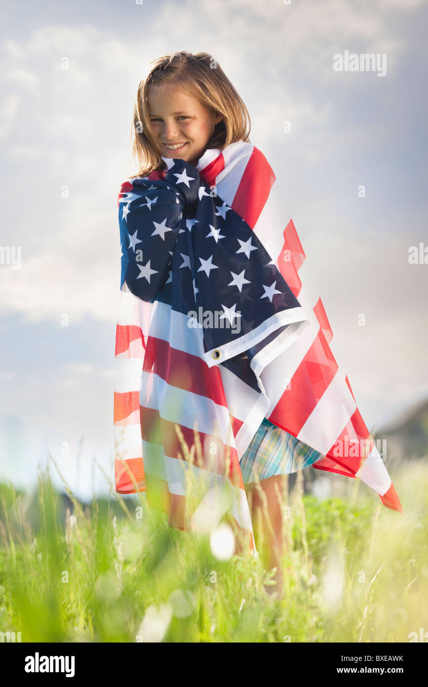 Young girl draped in American flag Stock Photo