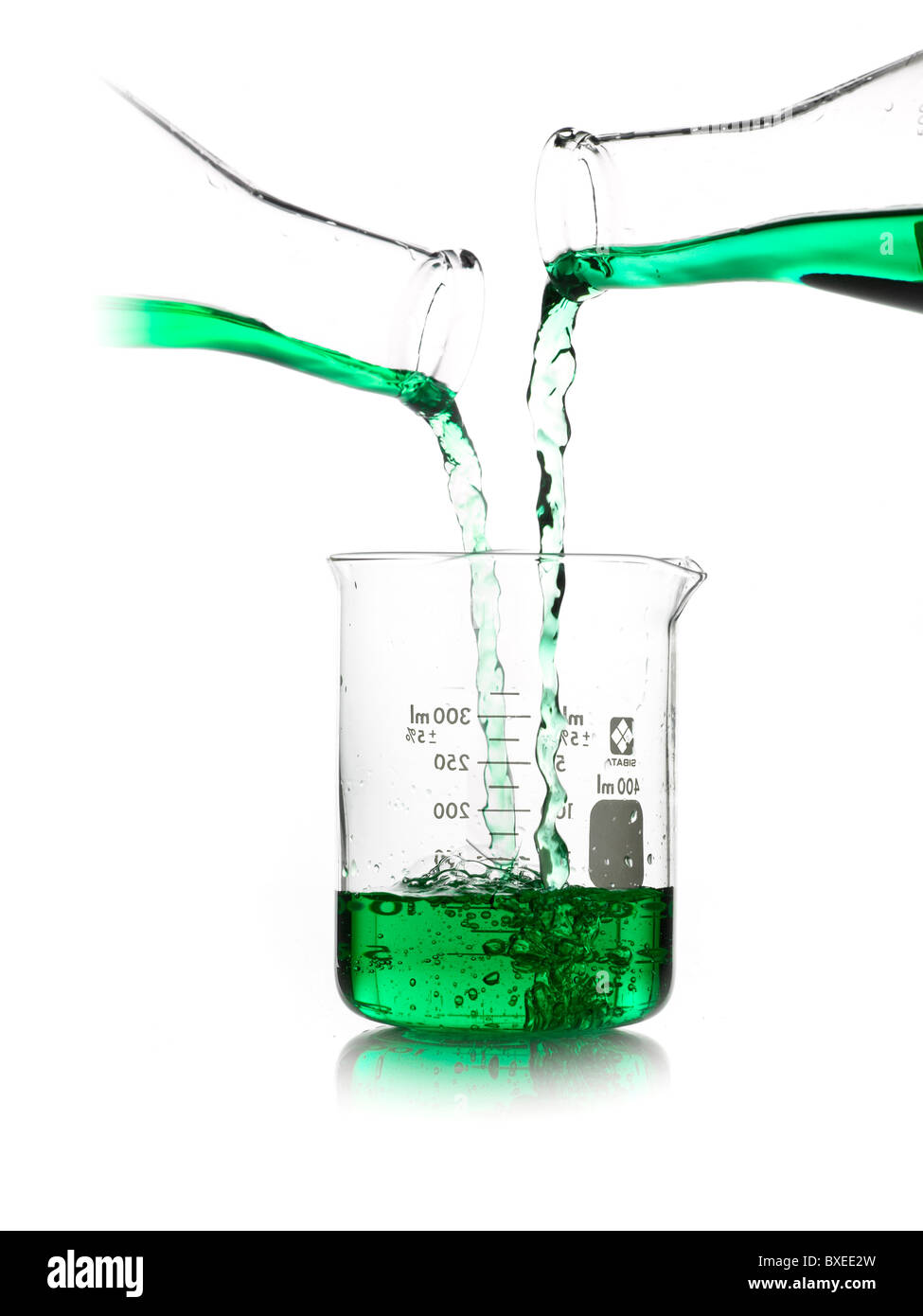 Green liquid being poured into measuring cup Stock Photo