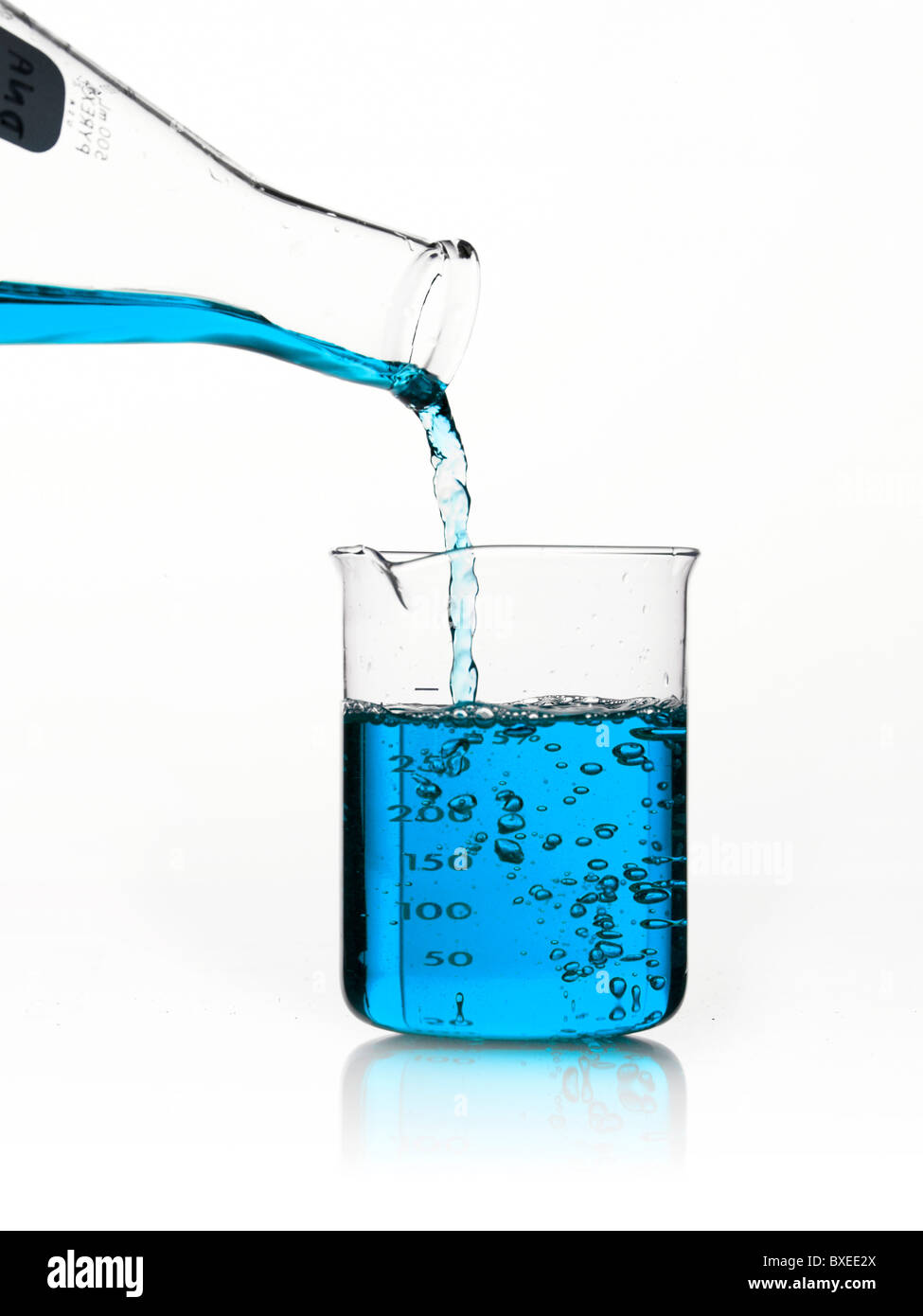 Blue liquid being poured into measuring cup Stock Photo