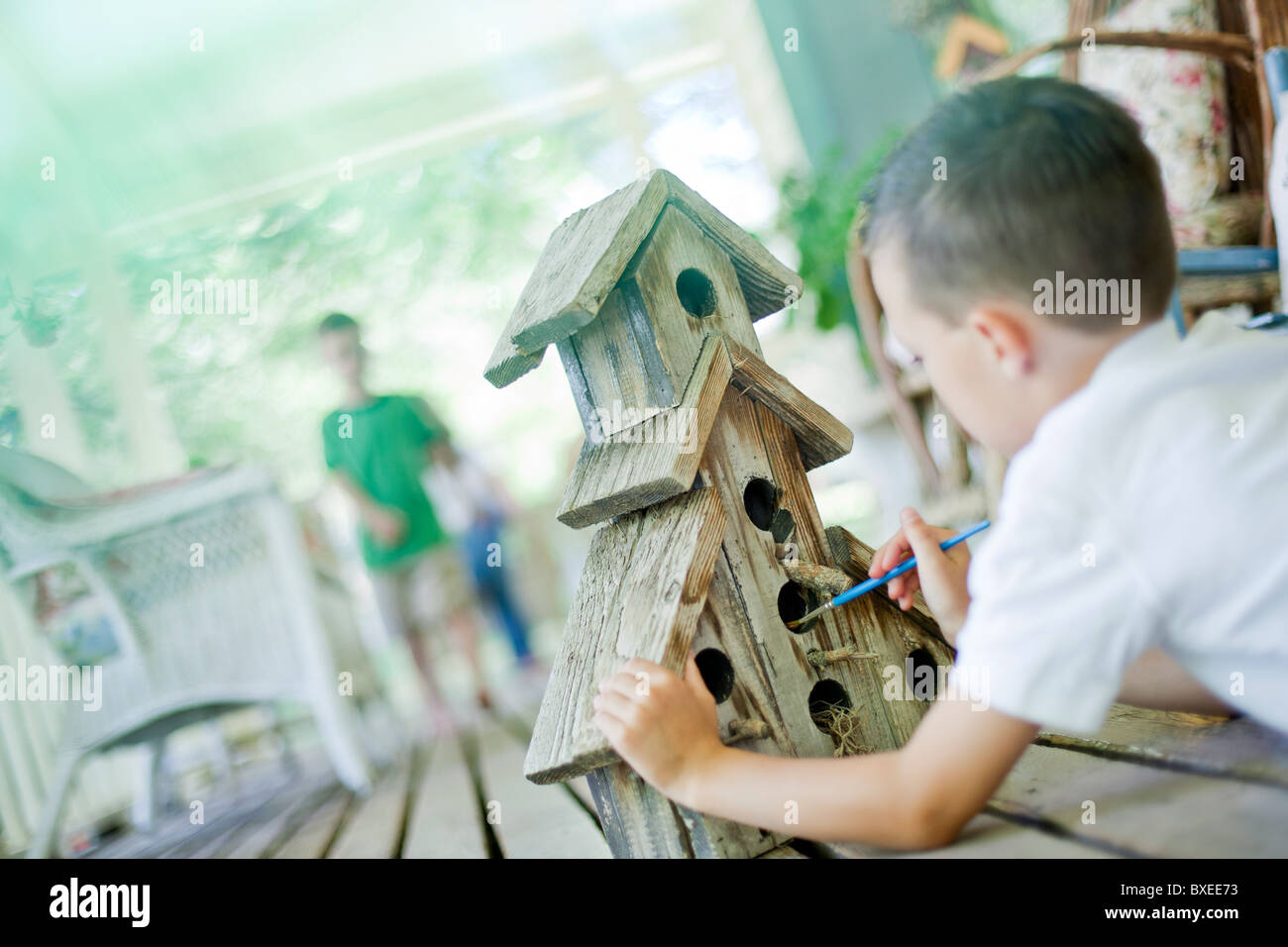 Young boy painting a birdhouse Stock Photo - Alamy