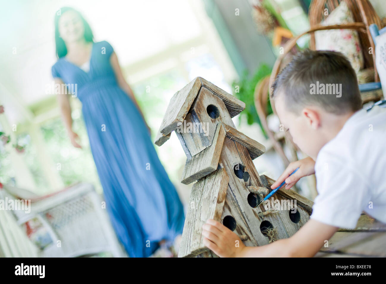Young boy painting a birdhouse Stock Photo - Alamy