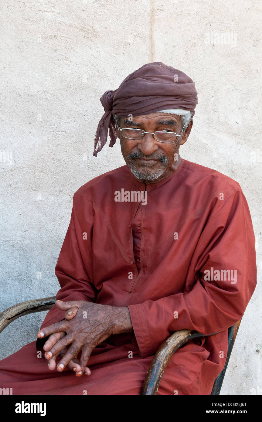 An old man with a traditional red cloth in Dubai Stock Photo