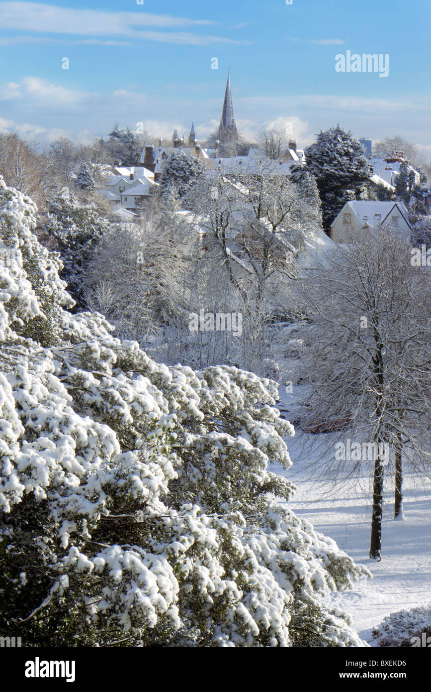 Winter scene with church spire,village and tress under new snow Stock Photo