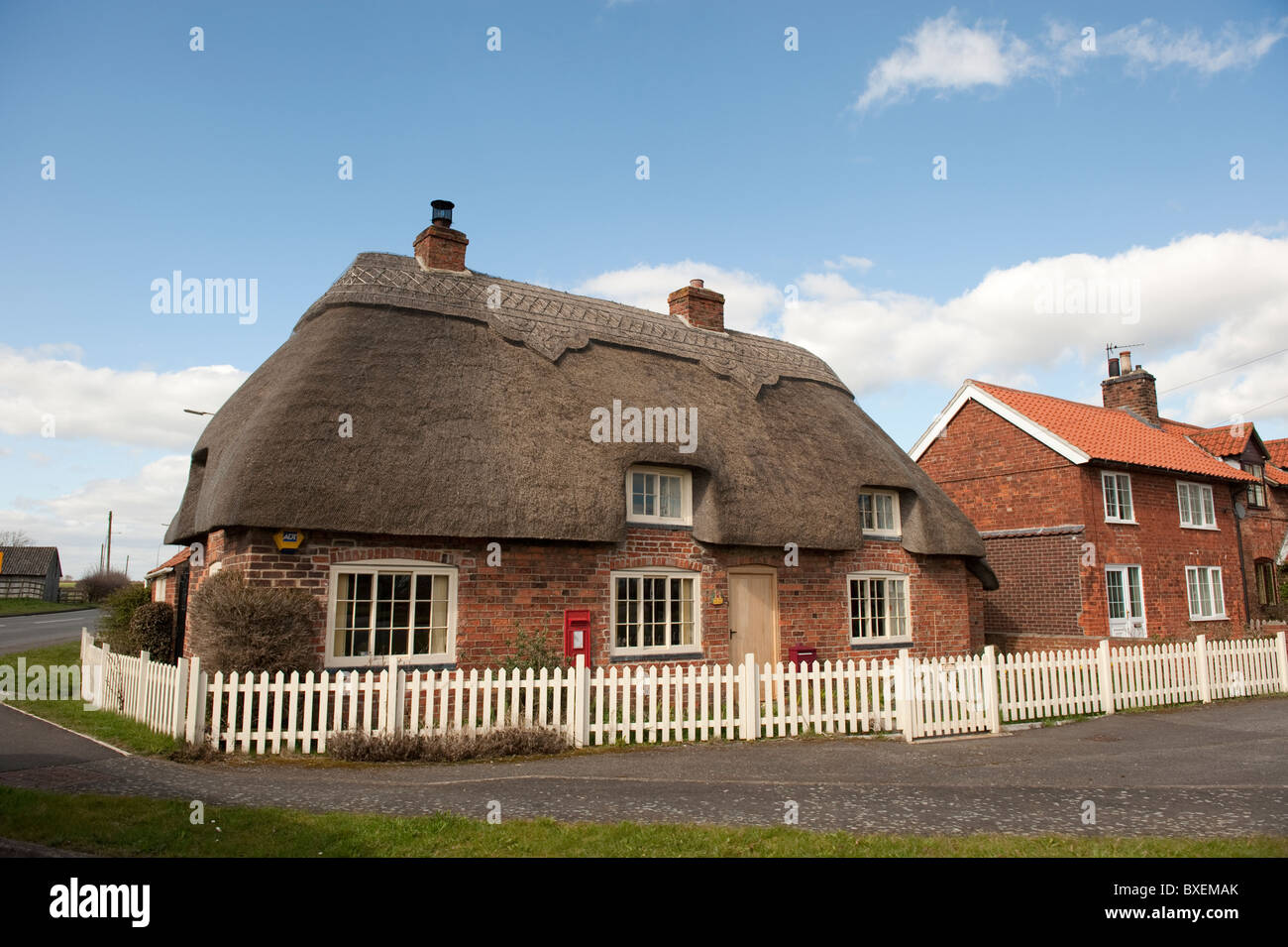 Traditional Thatched Cottage with Picket Fencing Stock Photo