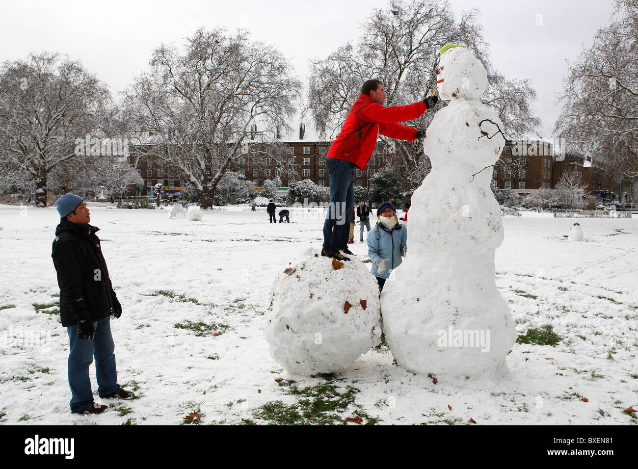 A guy is making a snowman after heavy snowfall in Kennigton Park, London, UK on December 18th, 2010. Stock Photo