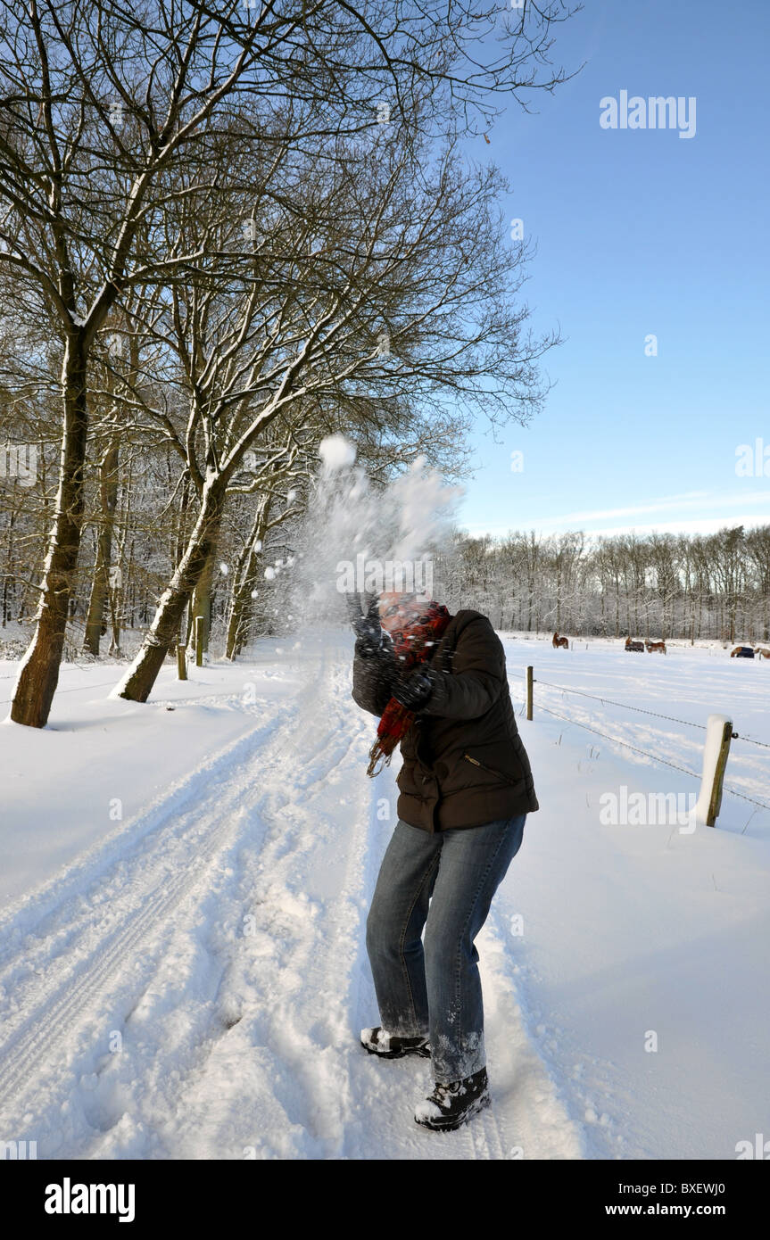 Senior woman catching a snowball in the wrong way Stock Photo
