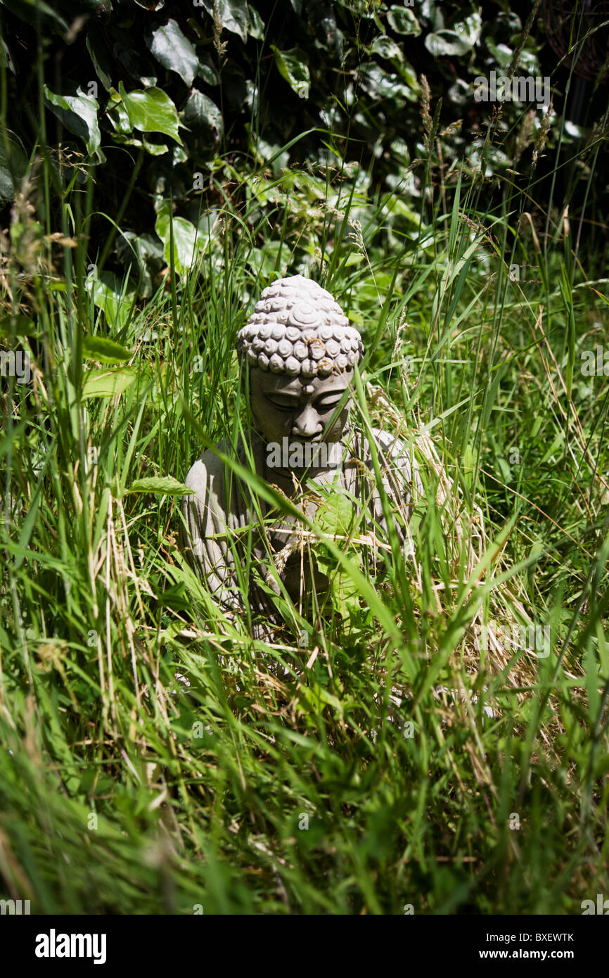 Buddha icon in long garden grass at the Rivendell Buddhist Retreat Centre, East Sussex, England. Stock Photo