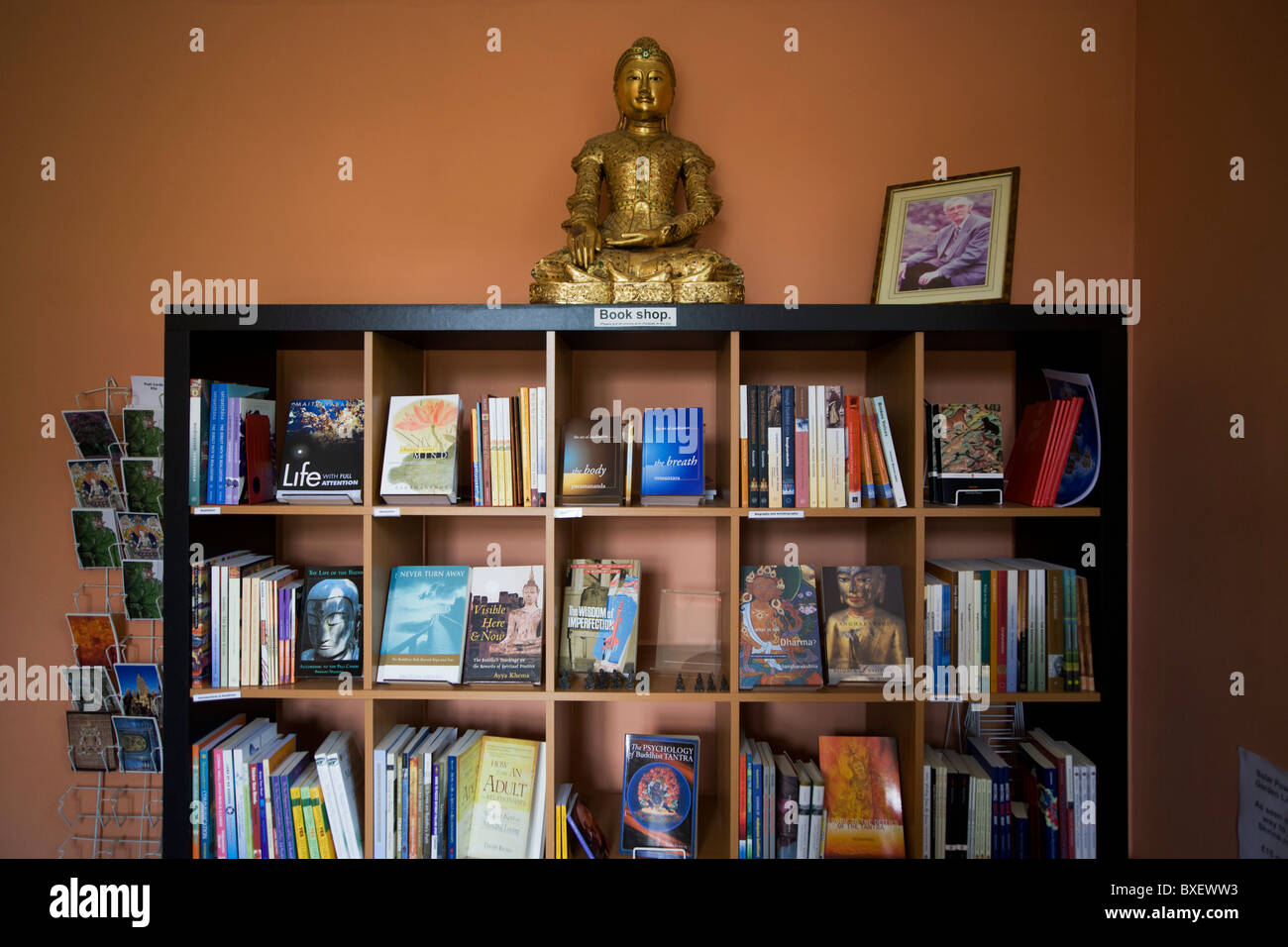 Bookshelves and Buddha at the Rivendell Buddhist Retreat Centre, East Sussex, England. Stock Photo