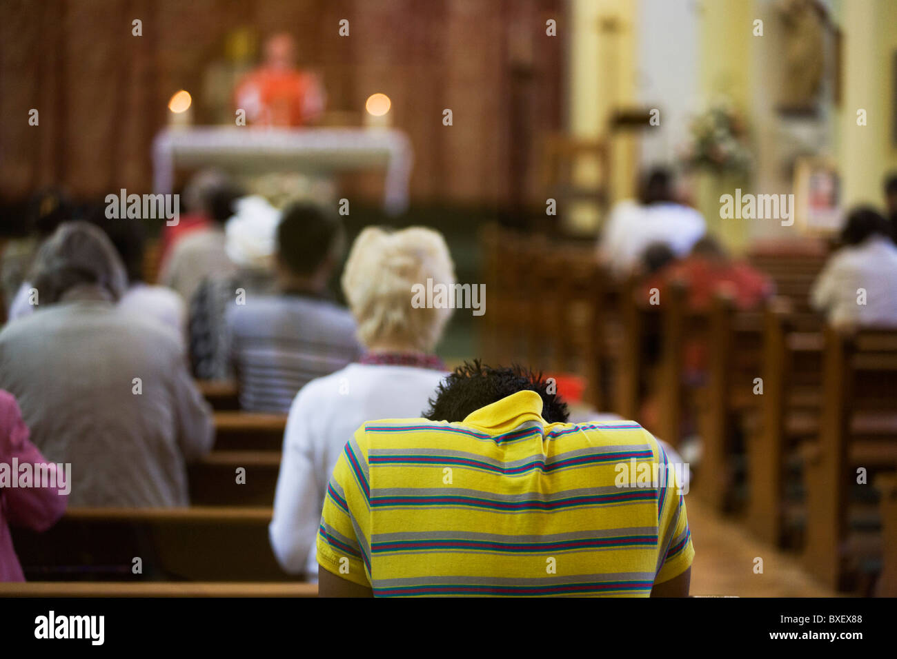 Priest gives blessings during daily Mass at St. Lawrence's Catholic church in Feltham, London. Stock Photo