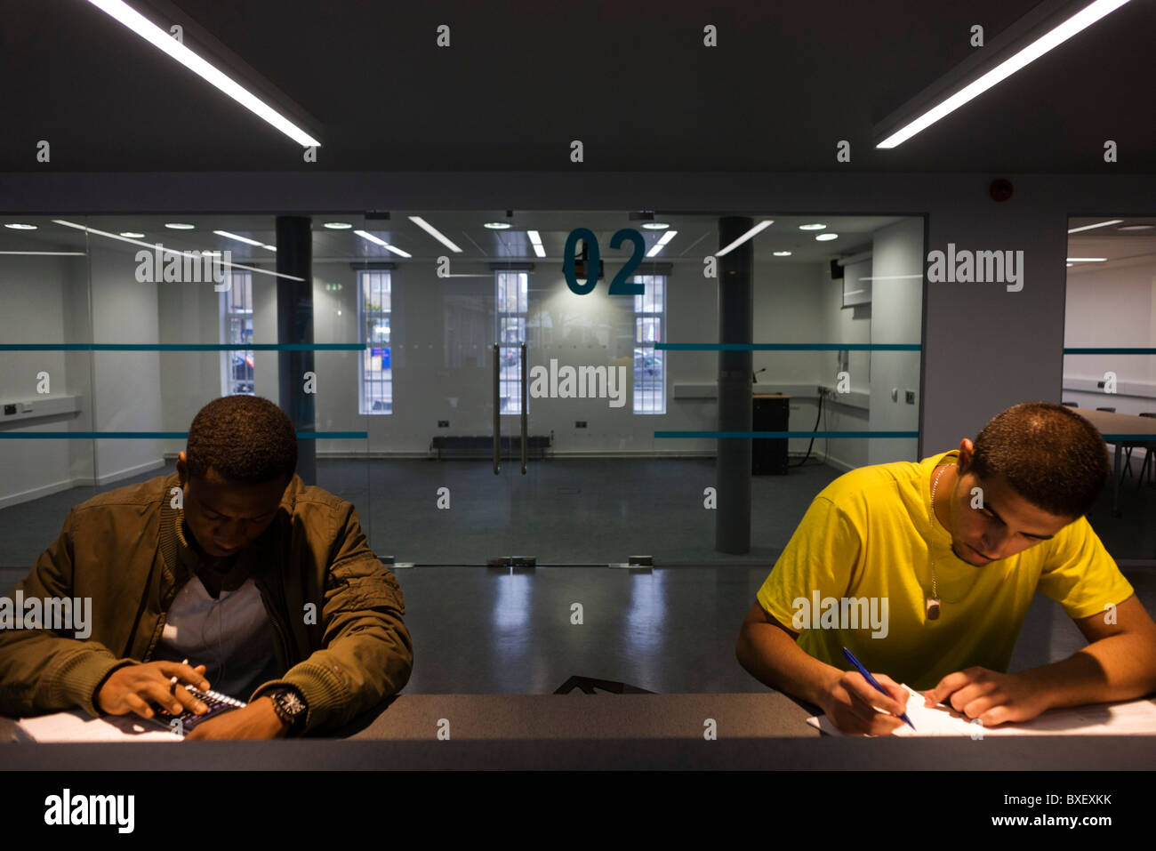 Young men study at workstations in communal area at London Metropolitan University's Holloway Road campus. Stock Photo