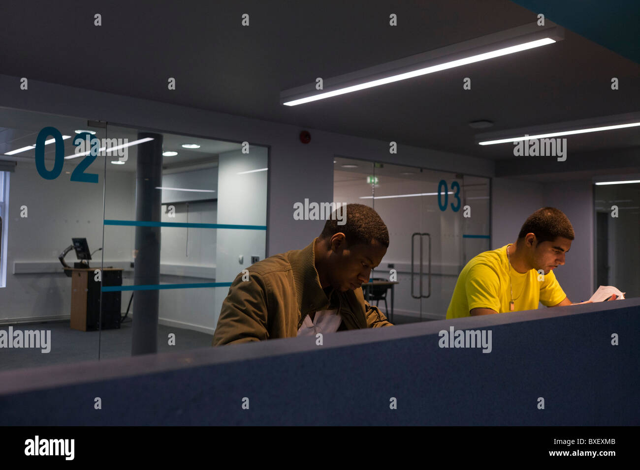 Young men study at workstations in communal area at London Metropilitan University's Holloway Road campus. Stock Photo