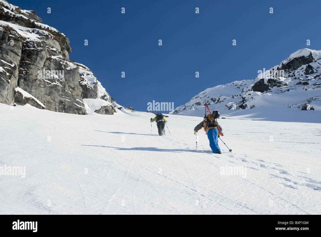 Two free skiers climbing up a snowy mountain side near Narvik, Norway Stock Photo