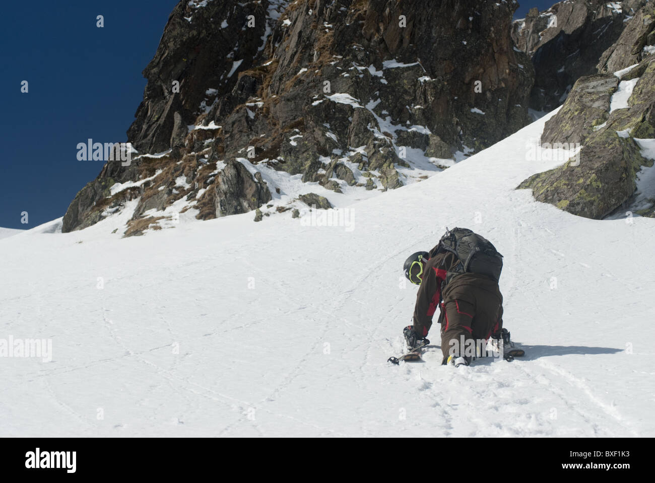 A free skier climbing up a snowy mountain side in Andermatt, Switzerland Stock Photo