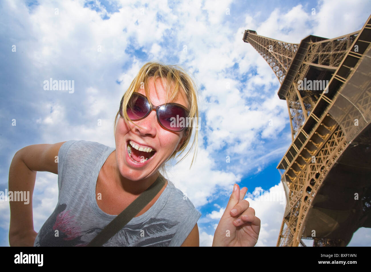 Woman pointing up at the Eiffel Tower Stock Photo