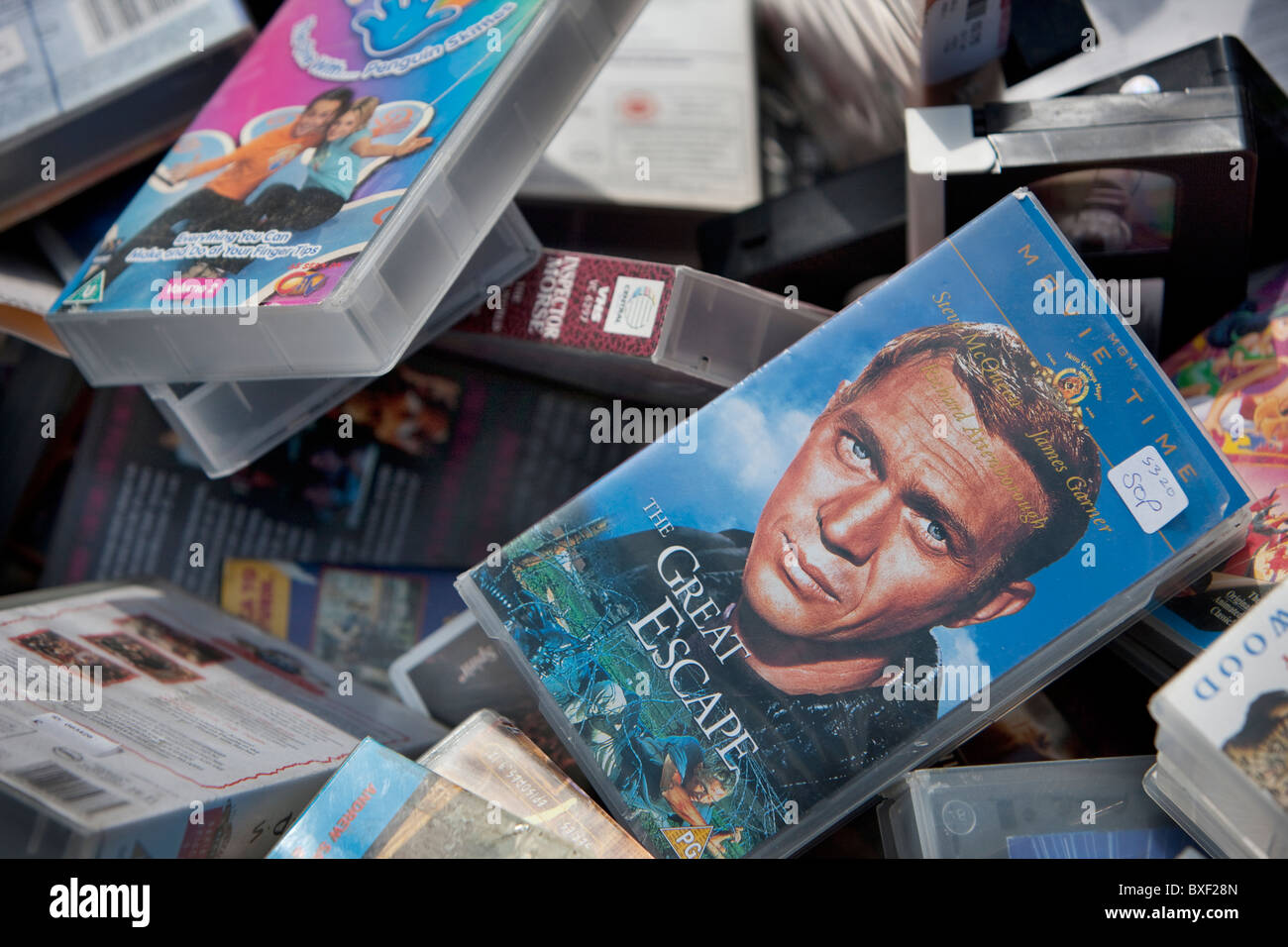 Old VHS tapes in a bargain bin. Stock Photo