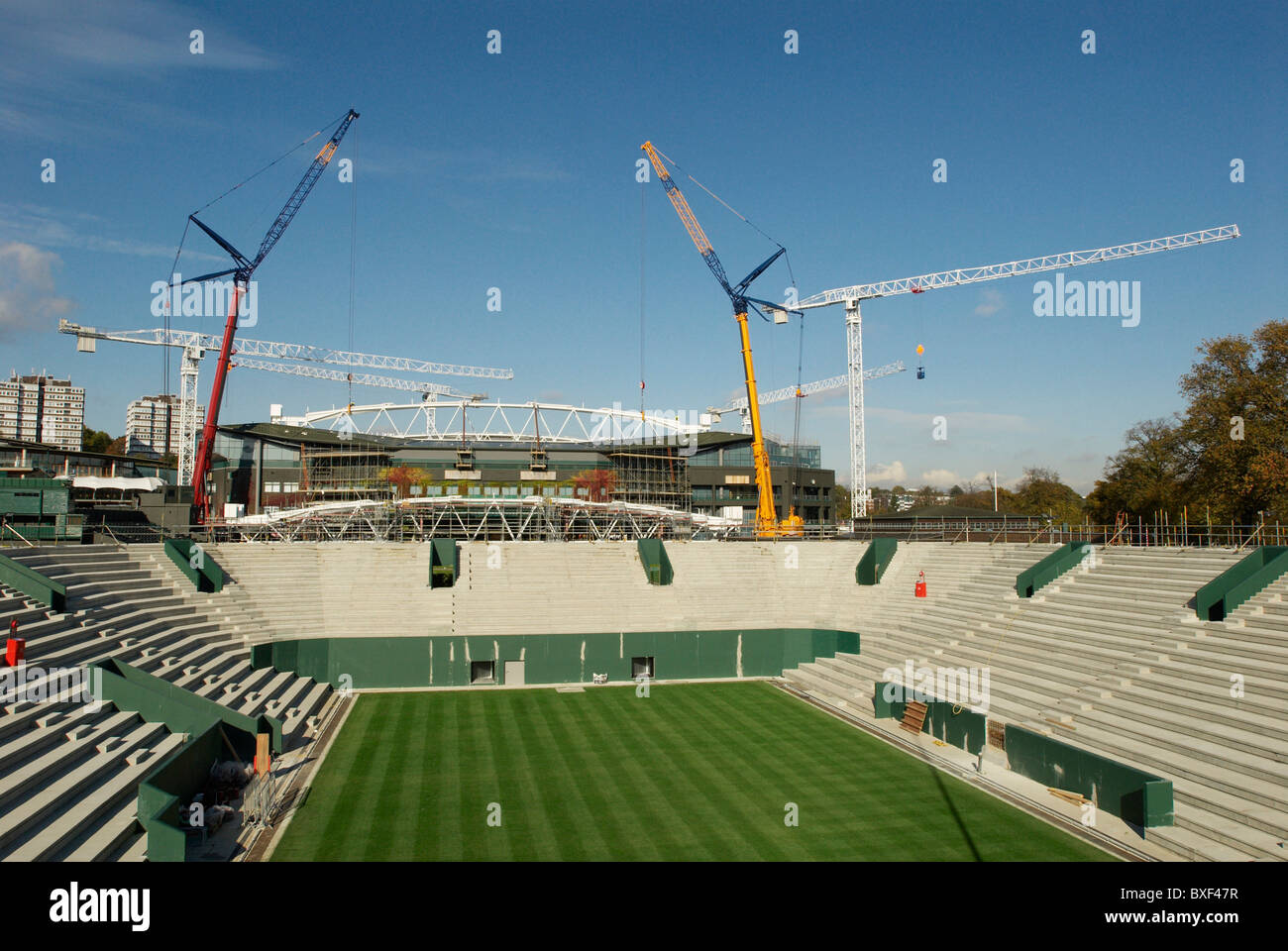 View from new No. 2 Court as two cranes work in tandem to lift roof trusses on to fixed roof of Centre Court, Wimbeldon. Stock Photo