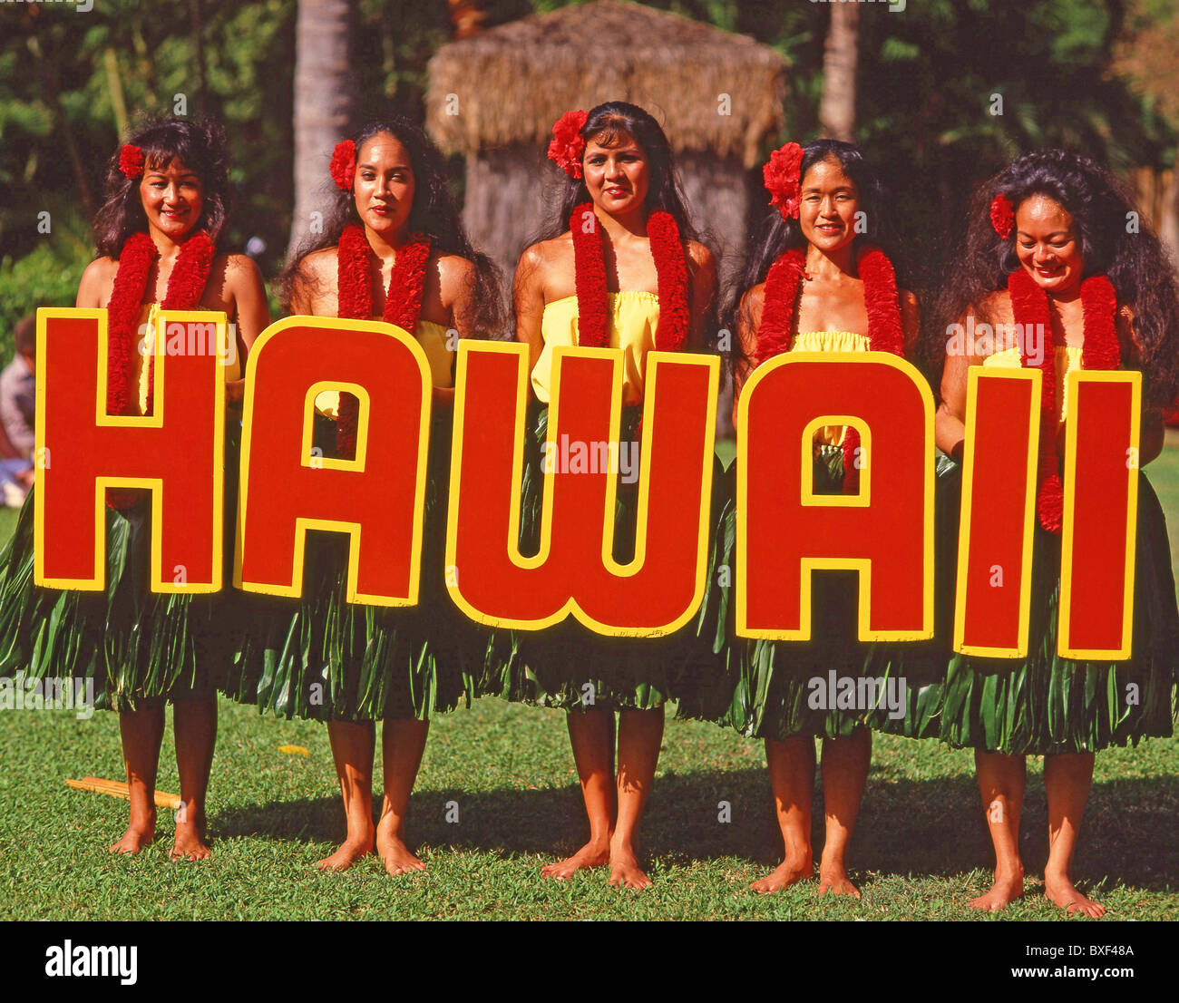 Hawaiian dancers holding 'Hawaii' sign, Kodak Hula Show, Honolulu, Oahu, Hawaii, United States of America Stock Photo