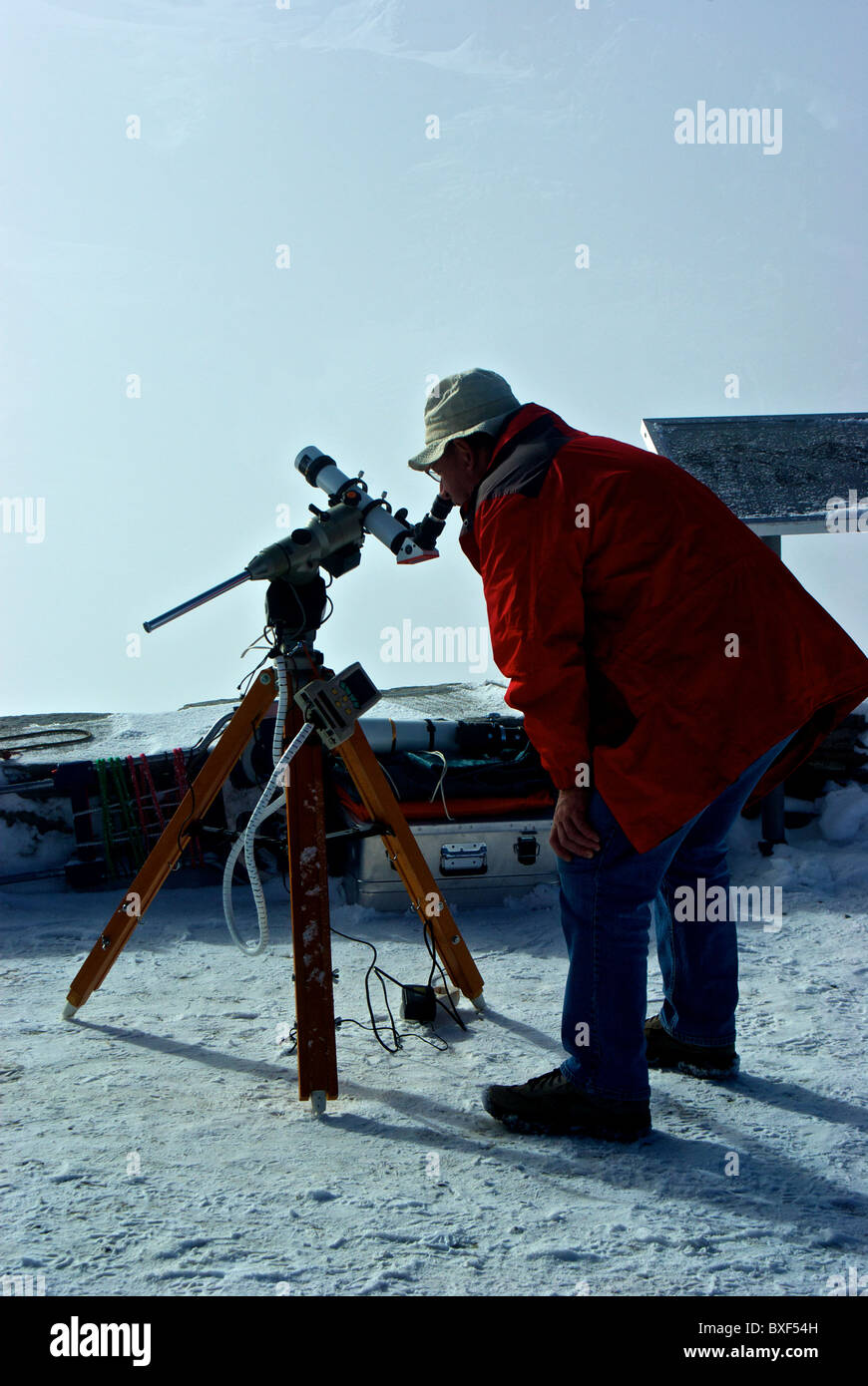 Astronomer using telescope studying sun atop Gornergrat alpine train station viewing platform Zermatt Switzerland Stock Photo