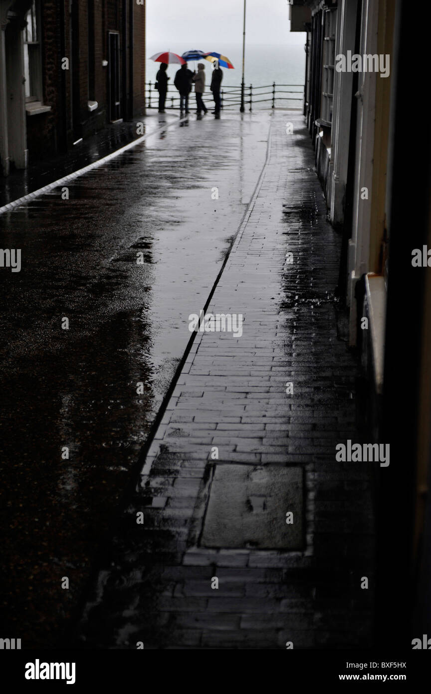 dull wet rainy day with group of friends carrying umbrellas in cromer Stock Photo