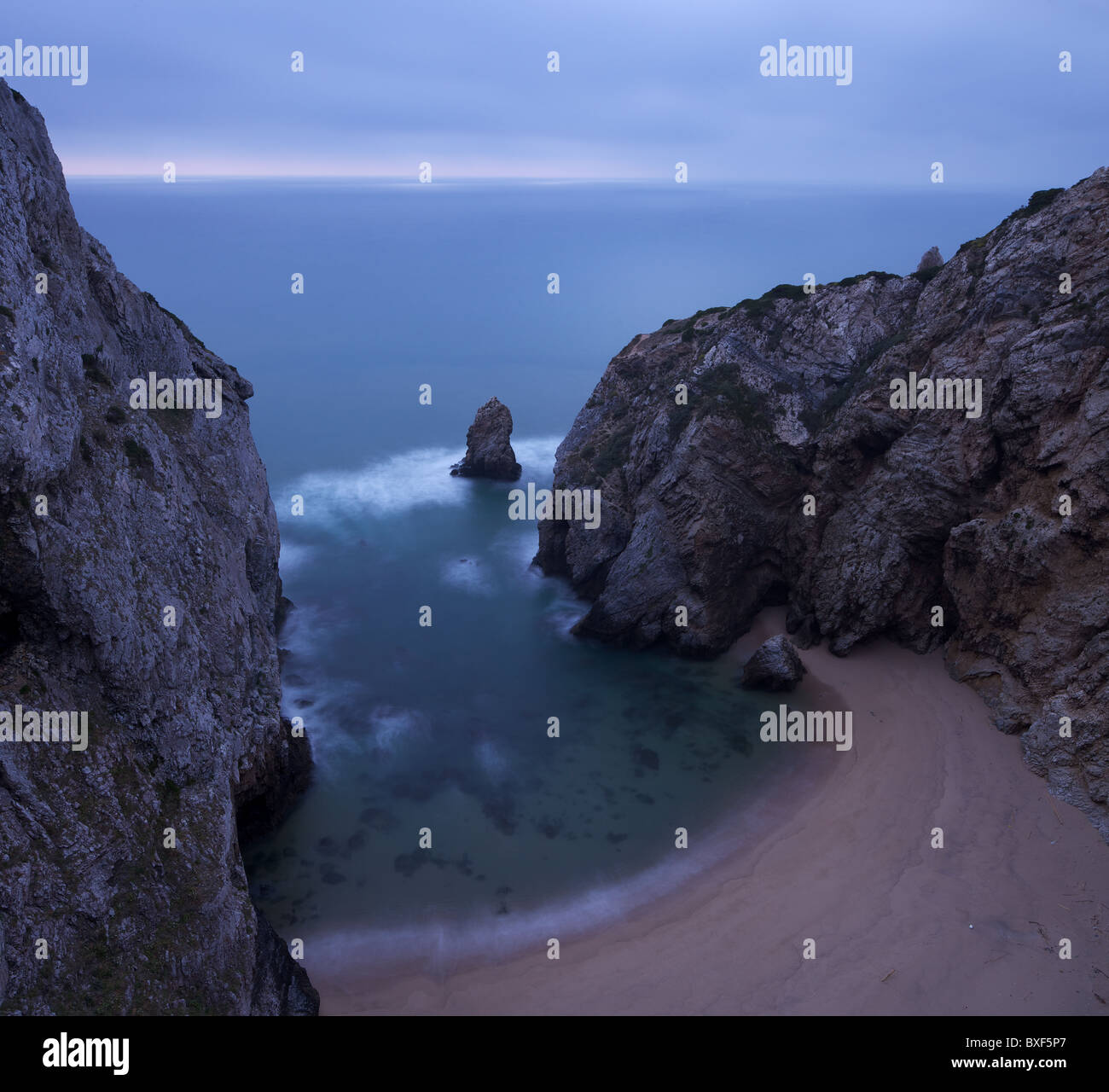 High view of a desert beach surrounded by huge cliffs on a cloudy day Stock Photo