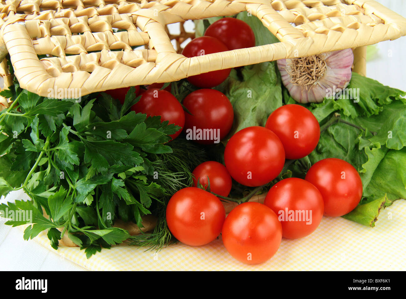 Cherry tomatoes garlic and herbs in a wicker basket Stock Photo - Alamy