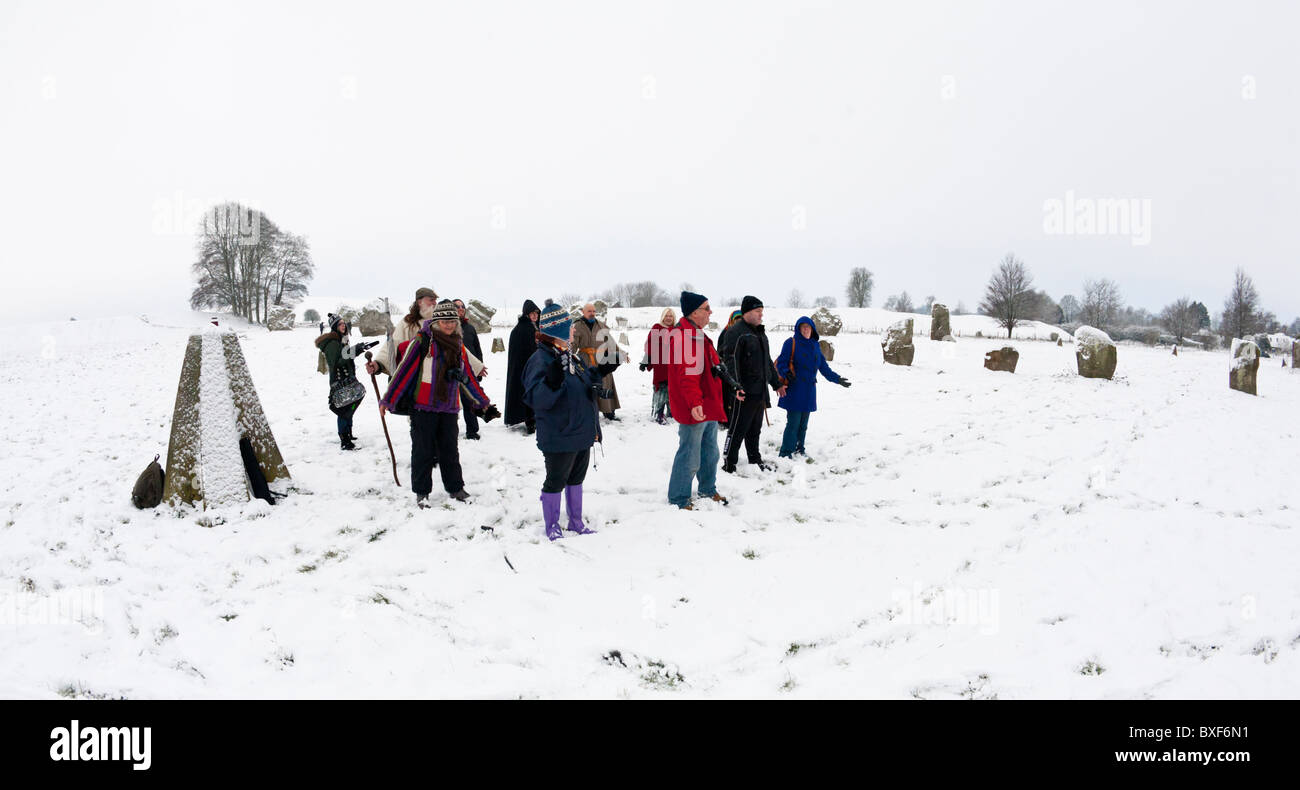 Druids celebrating the Winter Solstice in the snow at Avebury stone circle, Wiltshire, UK Stock Photo