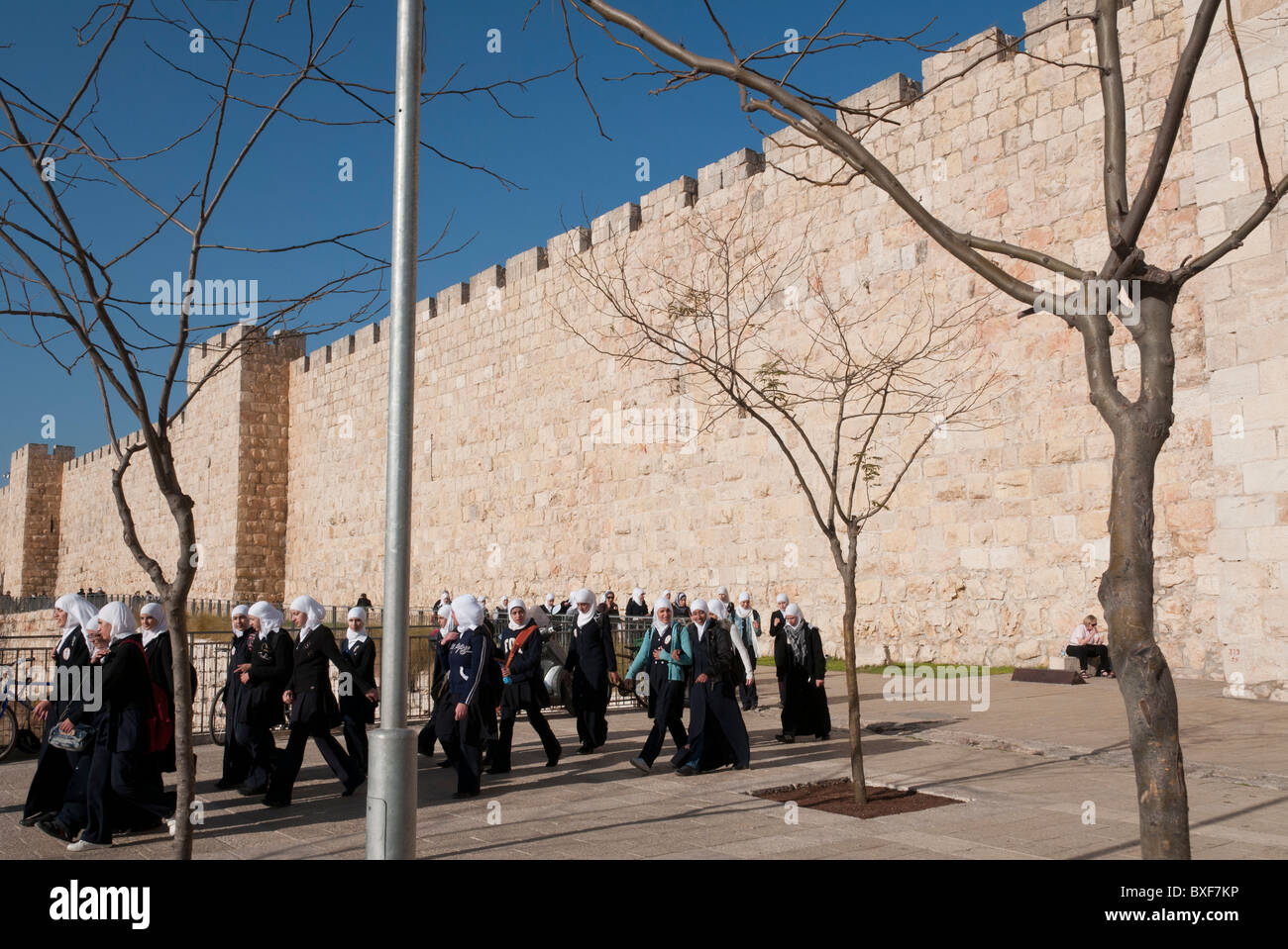 group of palestinian female youngsters with veil walking by the city walls of Jerusalem Old City Stock Photo
